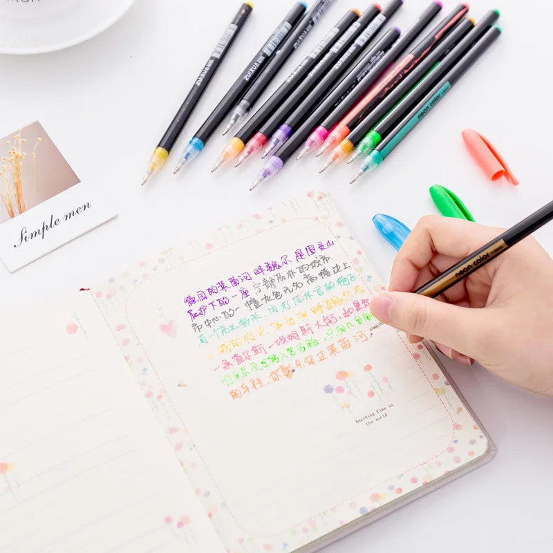 A collection of 24 gel pens in various pastel, metallic, neon, and glitter colors laid out on a white surface next to a noteb