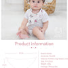 A baby wearing a white soft cotton bib with cartoon prints sitting on a white rug.