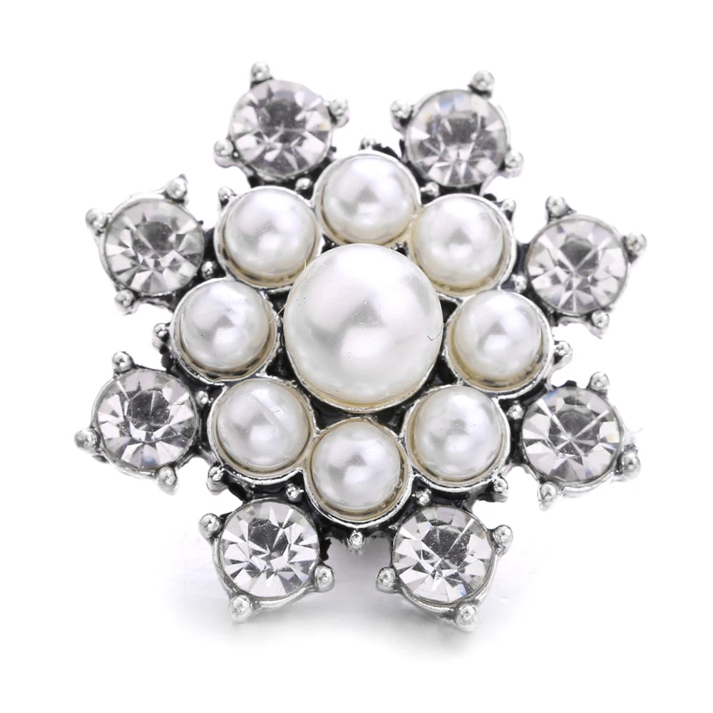 A cluster of small, round, silver-toned metal snap buttons used for jewelry making.