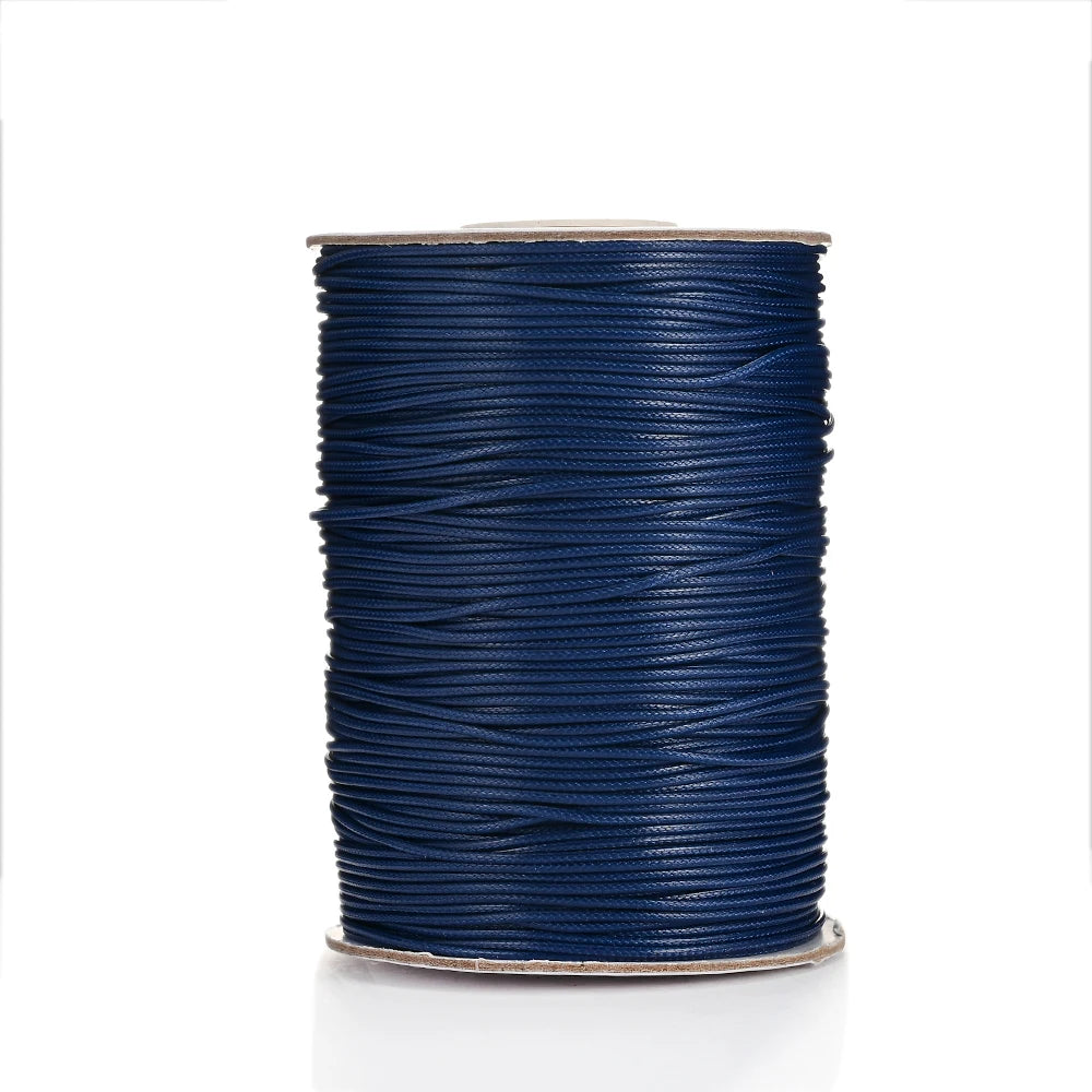 A spool of dark blue waxed cotton cord used for jewelry making.