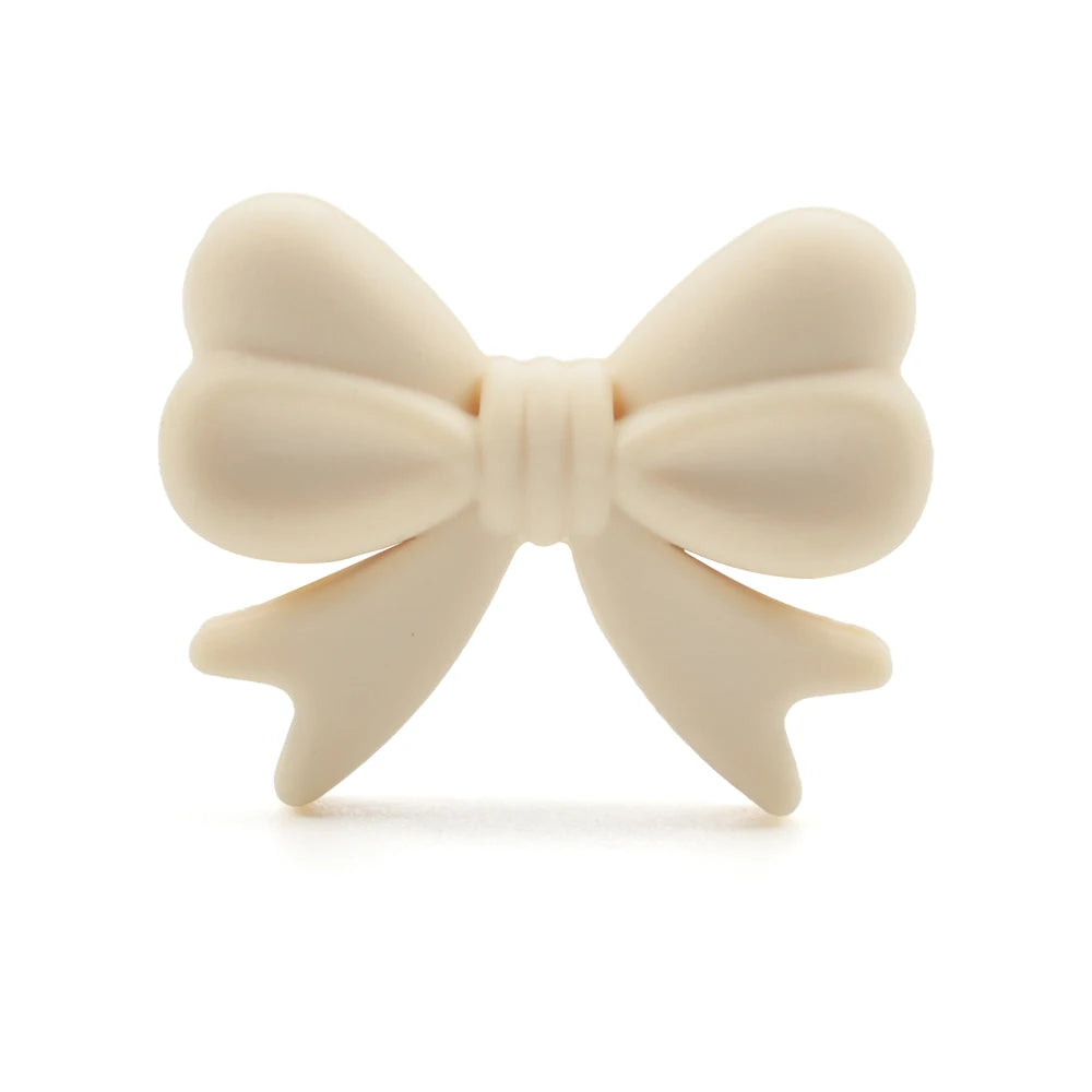 A light beige food-grade silicone bow or ribbon for jewelry making and DIY crafts.
