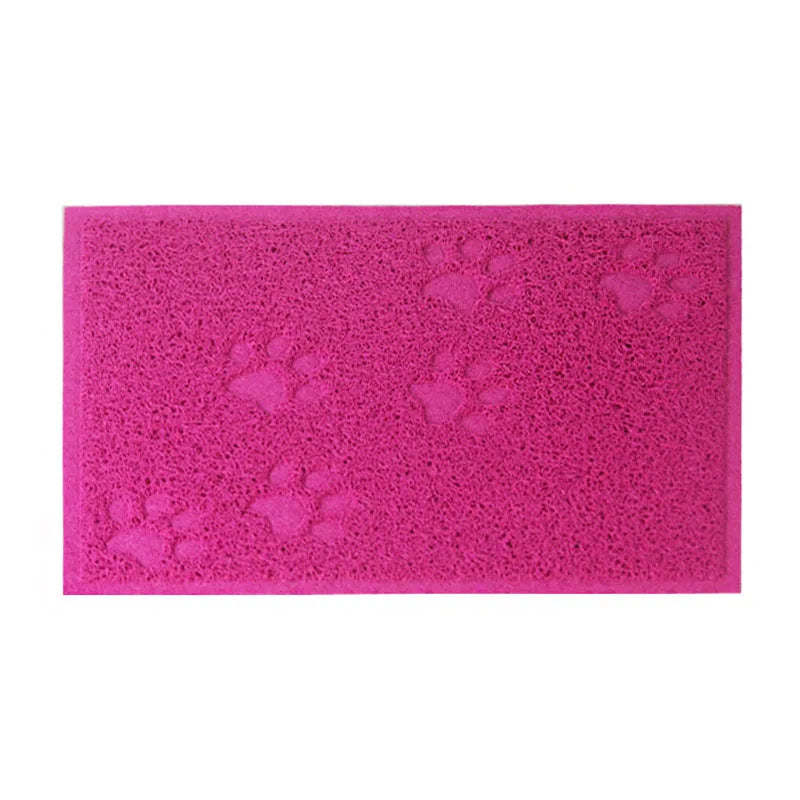 A bright pink cat litter mat with embossed paw print designs.