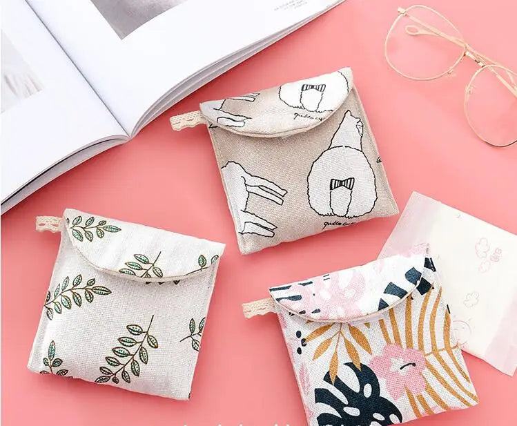 A collection of cosmetic storage pouches in various floral and neutral patterns, including a light beige pouch and a pink pat