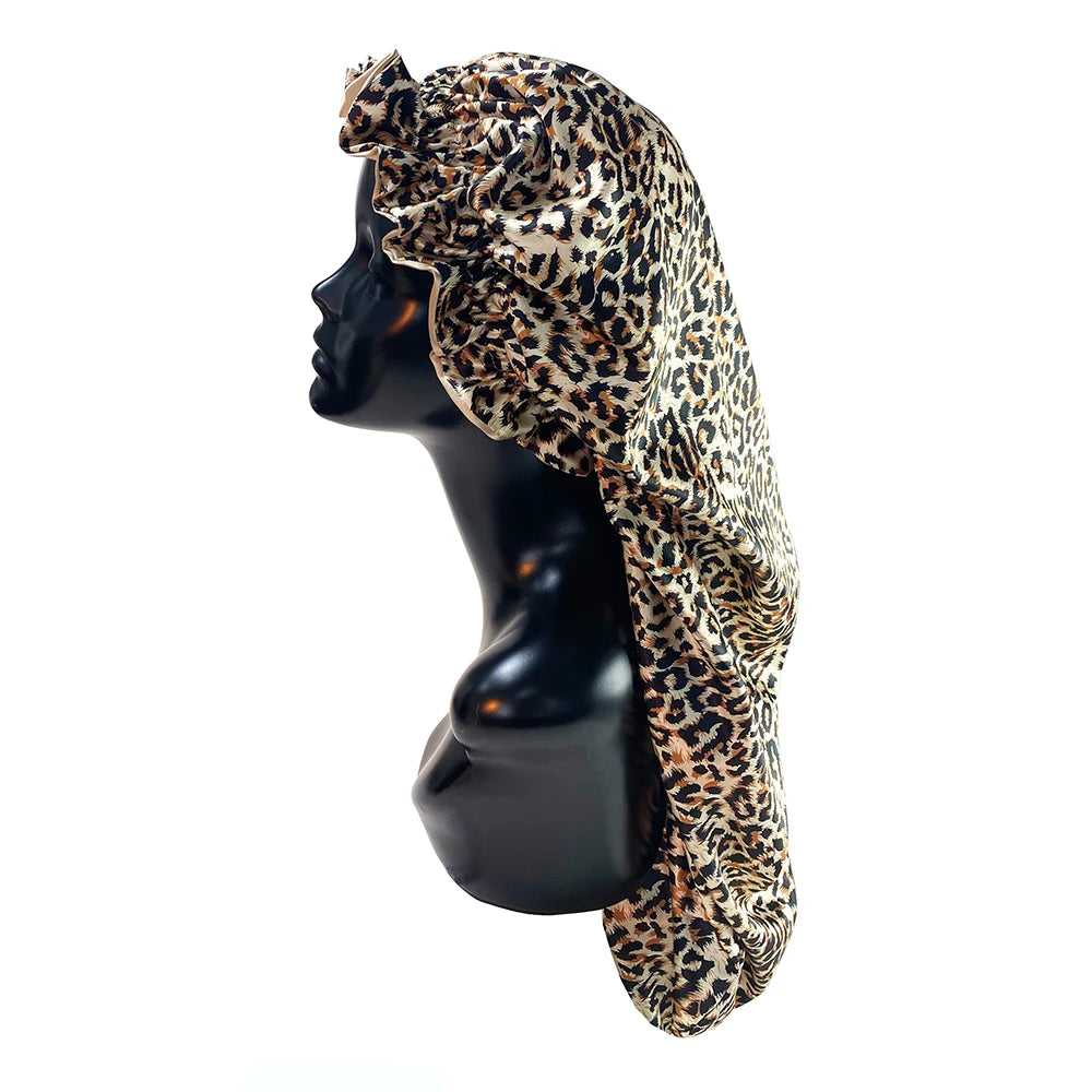 A black mannequin head wearing a leopard print satin hair bonnet.
