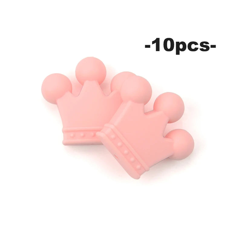 A pile of ten pink silicone crown beads for jewelry making and DIY crafts.
