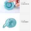 A hand is holding a clear blue suction cup hook, demonstrating its strong vacuum seal and PVC material.