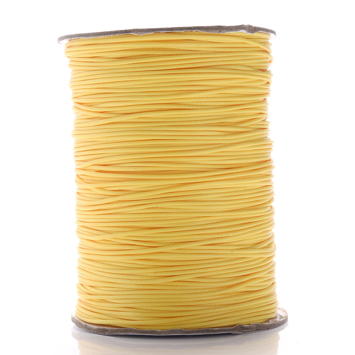 A spool of yellow waxed cotton cord used for jewelry making