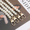 A strand of white pearls threaded onto a gold-toned chain strap for a handbag or purse.