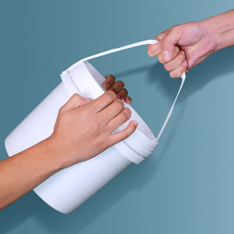 A hand is holding a white plastic bucket with a leakproof lid against a blue background.