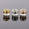 Three silicone rubber ear back stoppers with copper rings shown on a reflective surface.