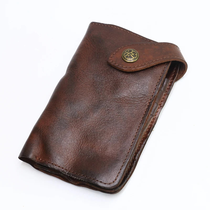 A brown vintage cowhide leather bi-fold wallet with a brass logo detail.