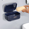 Wall-mounted soap dish with a hinged lid shown against a gray wall, highlighting its durable and convenient features.