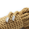 A close-up of thick, tan braided rope with silver metal tips used for Shibari bondage.