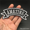 Black and white embroidered banner patch with the word AMAZING on a hand
