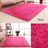 Una vibrante alfombra de felpa rosa exhibida sobre un suelo de madera claro.