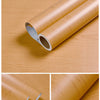 Rolls of natural wood grain self-adhesive wallpaper showing the texture and finish