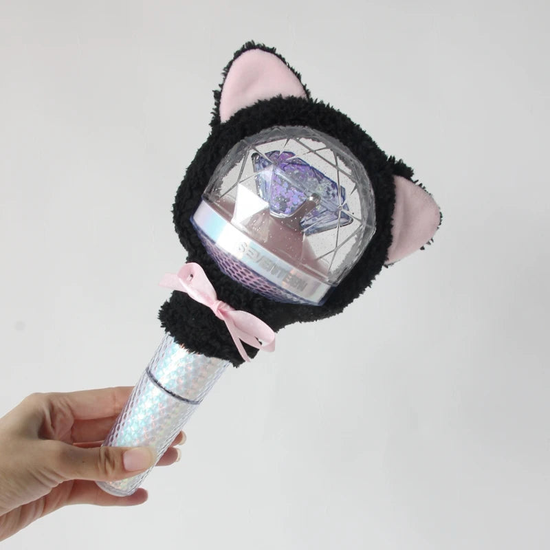 A plush cover shaped like a cat's head with pink ears and a clear sphere featuring a light stick design.