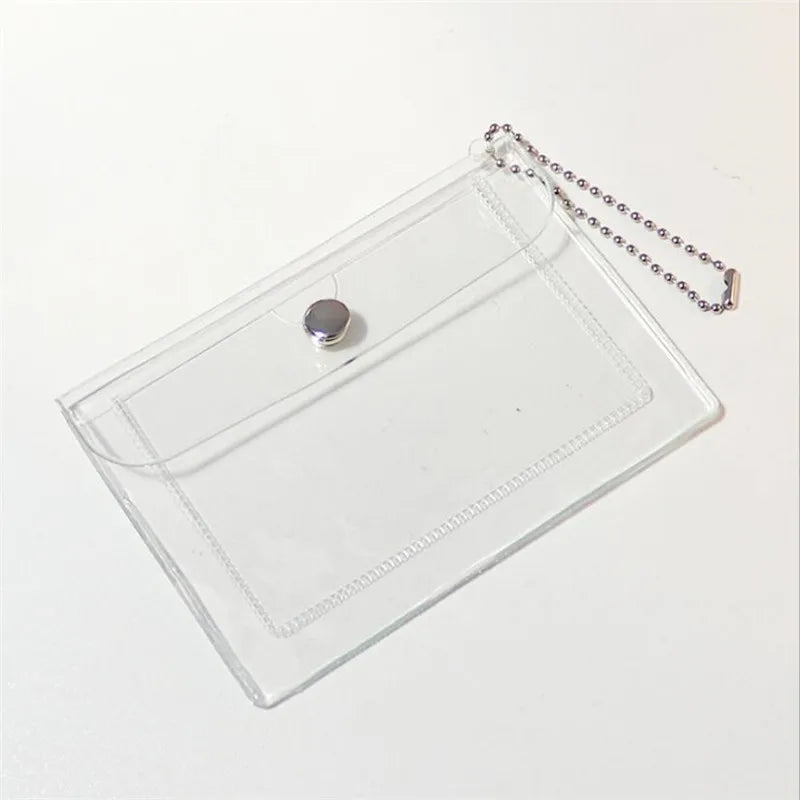 A clear PVC card holder with a silver chain attached, featuring a small, round, purple-colored charm.