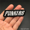 Black embroidered text PUNKERS on a fabric patch being held in a hand.