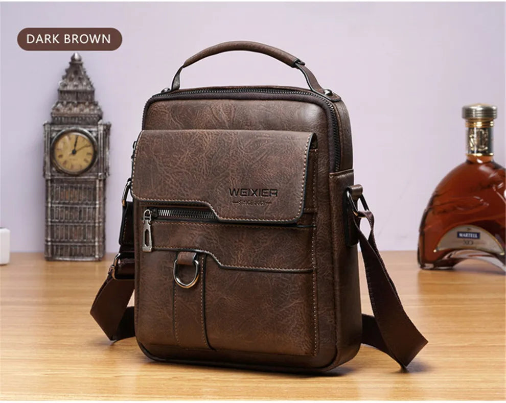 Dunkelbraune Vintage-PU-Leder-Crossbodytasche für Herren auf einer Holzoberfläche neben einer Standuhr.