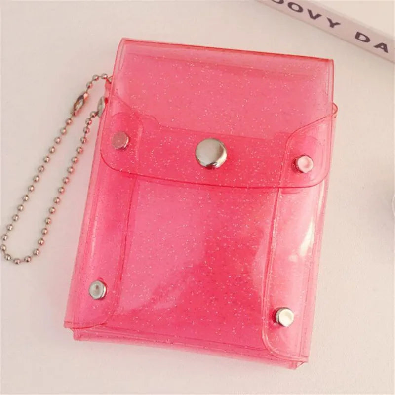 A pink glitter PVC card holder with a fold-over design and a silver chain attached.