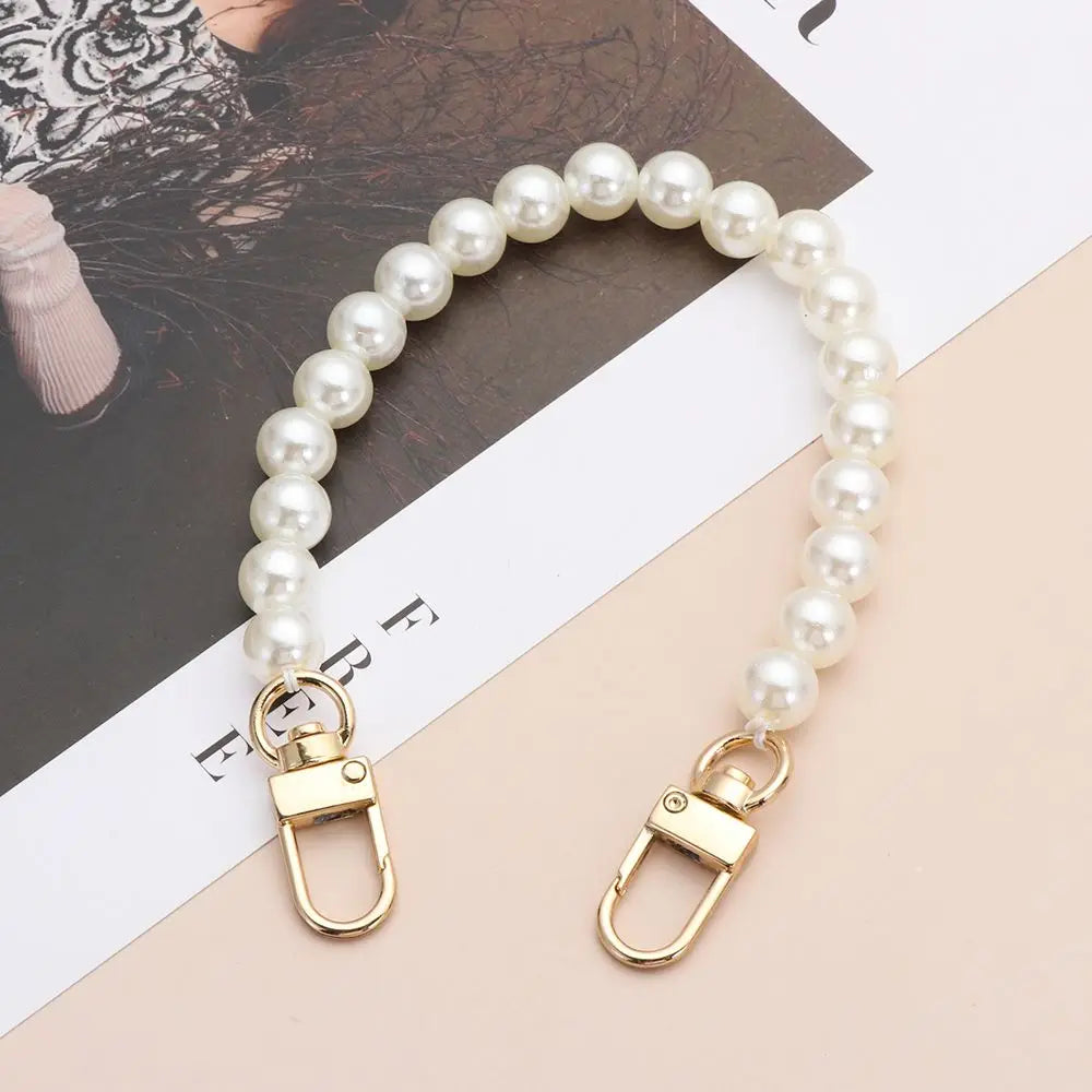 A strand of white pearls on a gold-toned chain strap for handbags or DIY purses.