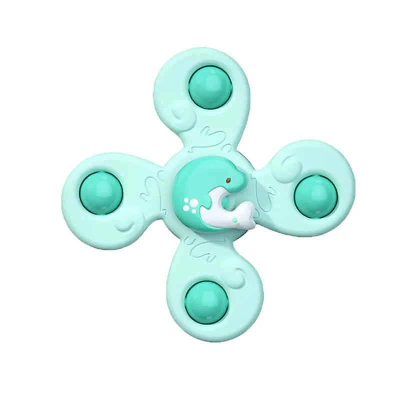 A light mint green suction cup spinner bath toy shaped like a whale for toddlers.