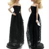 A fashion doll wearing a black lace dress and matching accessories.