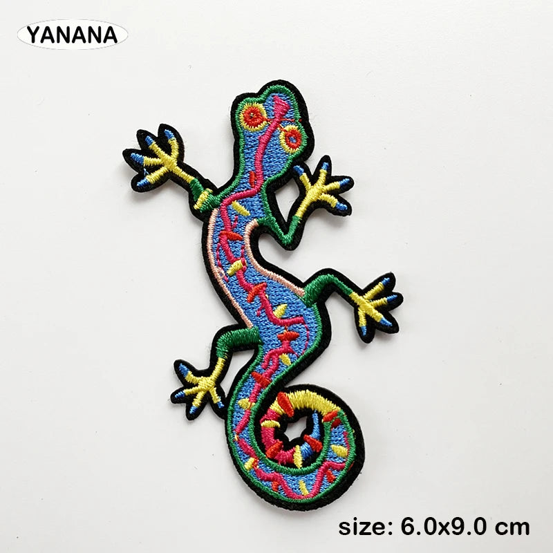 An embroidered patch of a colorful lizard or gecko with bright yellow and blue accents.