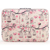 A pink floral patterned canvas laptop sleeve with a zippered closure featuring hanging bird cages and branches.