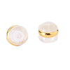 A clear silicone rubber ear back stopper with a gold-colored ring.