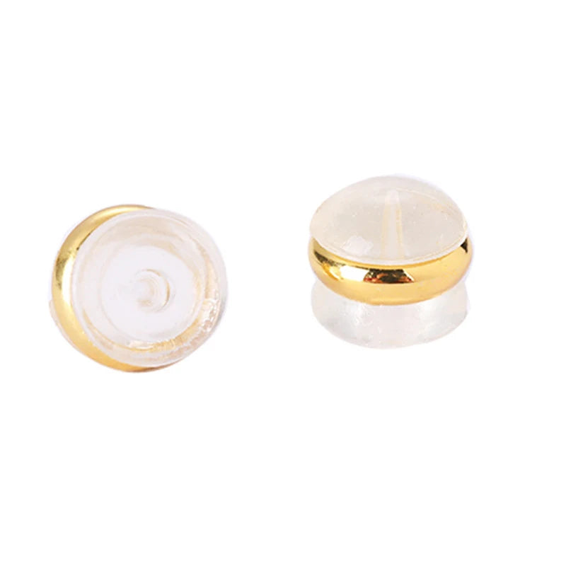 A clear silicone rubber ear back stopper with a gold-colored ring.