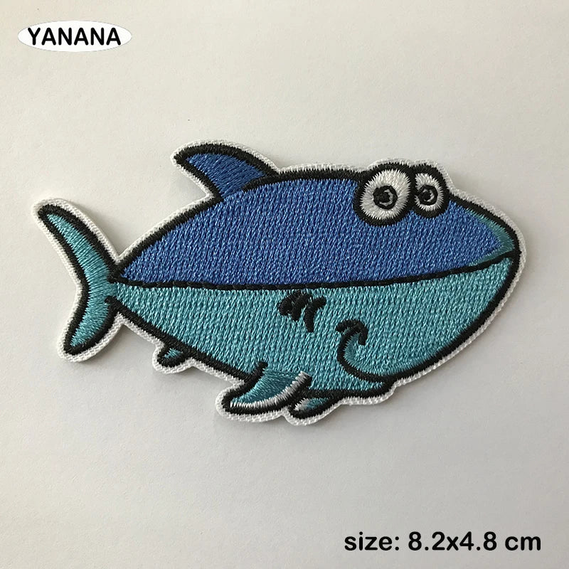 A blue and teal embroidered patch of a cartoon fish with large eyes.