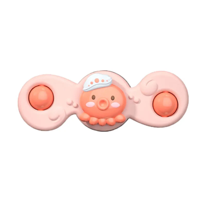 A pink suction cup spinner bath toy shaped like a cute, round face with small appendages.