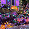 Outdoor Christmas display featuring illuminated trees, lights, and glowing gifts in a snowy garden setting.