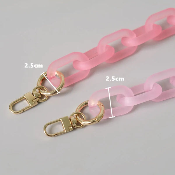 Nahaufnahme eines rosa Silikon-Kettenverschlusses mit goldfarbenen Schnallen und einem rechteckigen Plastik-Spanner.