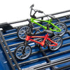 A set of three 1/10 scale RC crawler decorations including a green mountain bike, a red bike, and an oil drum.