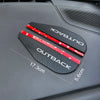 Black Outback mirror visors with red accents displayed on a dark car surface.