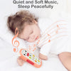 A baby is sleeping peacefully while holding an orange musical teether phone toy with lights and sounds.