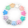 A collection of colorful food-grade silicone crown beads in various pastel colors arranged in a circle.