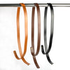 Three adjustable PU leather crossbody bag straps in brown, tan, and black hanging from a metal rod.