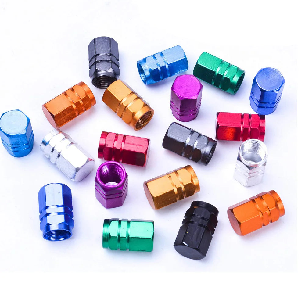A collection of colorful aluminum tire valve caps in various finishes and shapes.