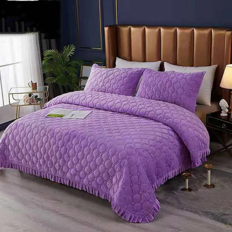 Purple quilted velvet bedspread with a diamond pattern on a bed in a bedroom setting.