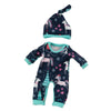A navy blue and pink patterned jumpsuit outfit for a baby doll, including a matching hat.