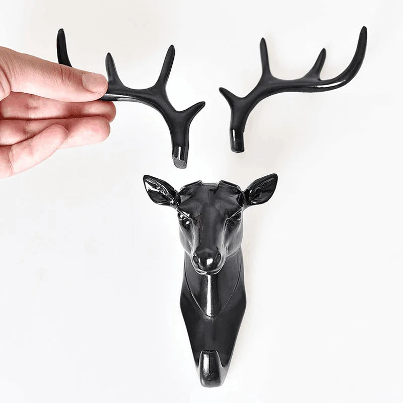 A black vintage deer head wall hook featuring antlers, displayed next to a sculpted deer head.