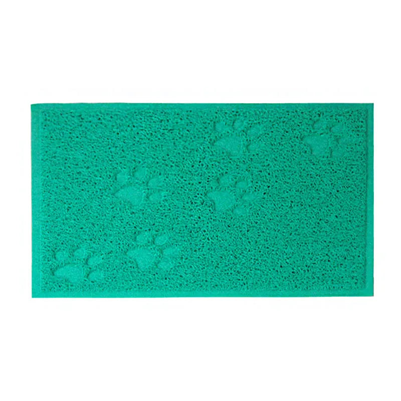 A rectangular teal cat litter mat with a repeating paw print design.