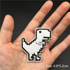 A hand holds a white embroidered punk skull patch for DIY use.