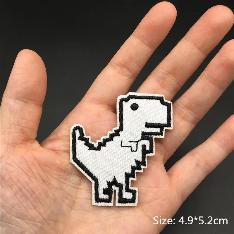 A hand holds a white embroidered punk skull patch for DIY use.