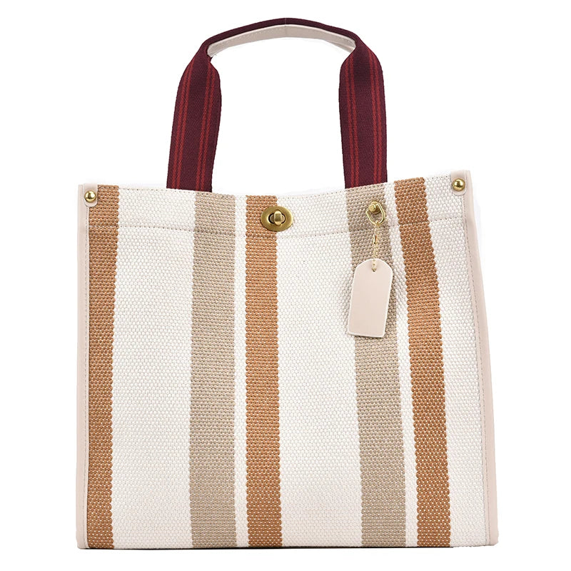 A beige and white striped canvas tote bag with brown straps.