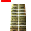 A stack of personalized matte gold name stickers for kids' belongings, featuring the name David.